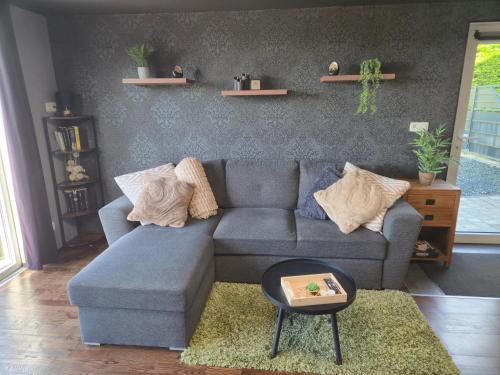 a living room with a blue couch and a table at Gîte L'Aventura in Vielsalm