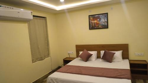 a bedroom with two beds and a picture on the wall at Hill Mountain Hotel in Chakarpur