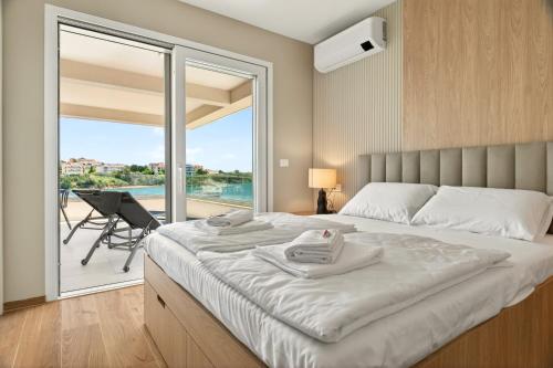 a bedroom with a large bed and a balcony at Smile Apartments in Povljana