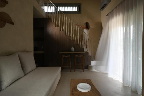 a woman walking down the stairs in a living room at Domus Gaia Suites in Nikiti