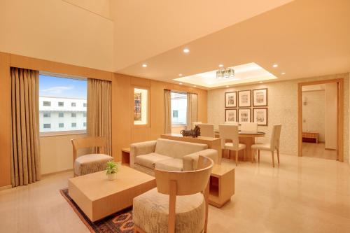 a large living room with a table and chairs at Lemon Tree Premier, Delhi Airport in New Delhi