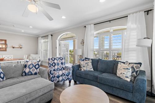 a living room with two couches and a table at The Blue Lagoon in Rosemary Beach