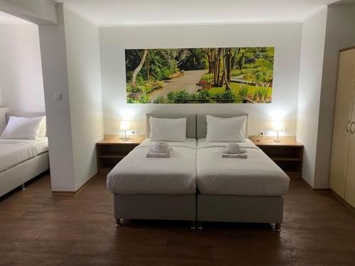 a bedroom with two beds and a painting on the wall at Silver Hotel Budapest City Center in Budapest