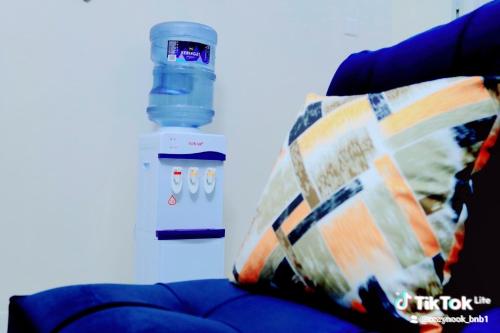 a pillow sitting on a couch next to a water bottle at Purity homes ruiru in Ruiru