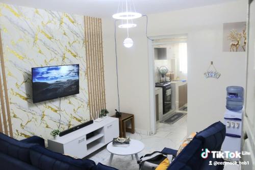 a living room with a couch and a tv on a wall at Purity homes ruiru in Ruiru