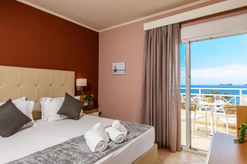 a bedroom with a bed with a view of the ocean at Sunny Hotel Thassos in Chrysi Ammoudia