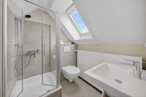 a bathroom with a shower and a toilet and a sink at Gurtdeel 1000 Sterne-Suite in Hörnum