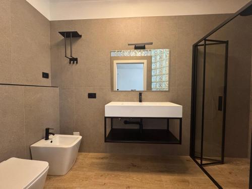 a bathroom with a sink and a toilet and a mirror at B&B La Vigna dei Fratelli in lido degli scacchi