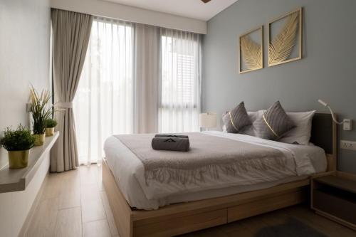 a bedroom with a large bed and a large window at Cassia Residence by Metrika, Laguna Phuket in Laguna Phuket