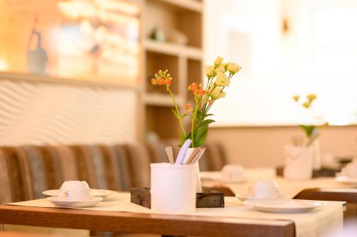a wooden table with a vase with flowers on it at Hotel zur Seemöwe in Insel Poel