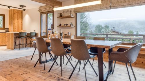 a dining room with a table and chairs and a large window at Chalet Le Savoy in Chamonix