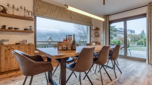 a dining room with a table and chairs and a large window at Chalet Le Savoy in Chamonix