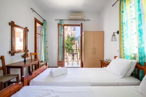 a bedroom with two beds and a window at Fotini Rooms in Skopelos Town
