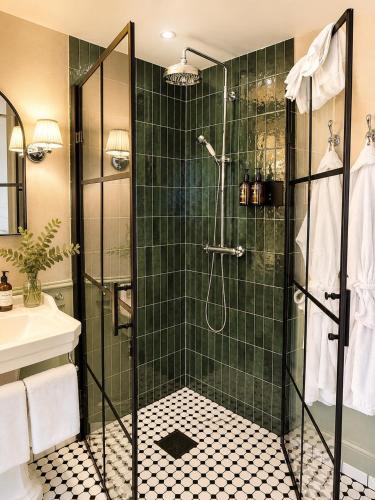 a bathroom with a shower with green tile at Vilma Sjøbad in Filtvet