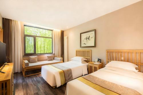 a hotel room with two beds and a window at Mainland Chinese Only-Qinhuangdao Xinting Calligraphy Hotel in Qinhuangdao