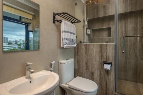 a bathroom with a toilet and a sink and a mirror at Hotel Raha Tower in Dar es Salaam