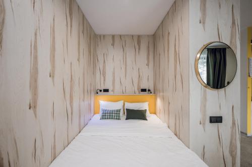a bedroom with a bed with a wooden wall at Aparthotel "Mayak Yablunytsia" in Yablunytsya