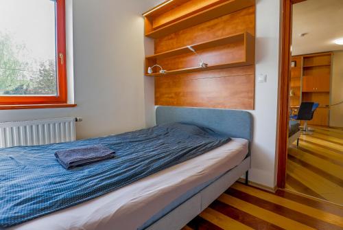 a bedroom with a bed with a blue blanket at Balaton Vista in Balatonfüred