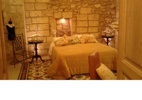 ein Schlafzimmer mit einem Bett in einer Steinwand in der Unterkunft Borgoterra in Martano