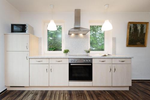 a kitchen with white cabinets and a stove at Gut Staberhof Staberpark in Staberdorf