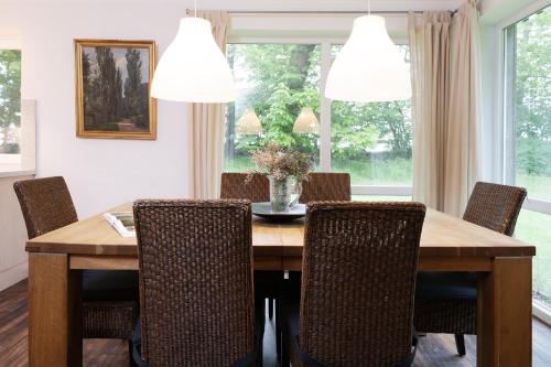 a dining room with a wooden table and chairs at Gut Staberhof Staberpark in Staberdorf