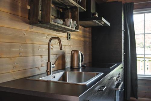 a kitchen with a stainless steel sink and a window at Manndalen Sjøbuer in Samuelsberg