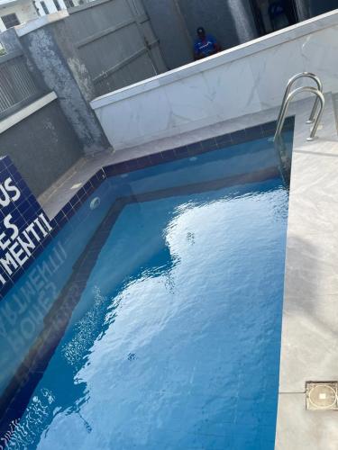 a swimming pool with blue water in a building at Precious home apartment II in Lekki