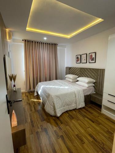 a bedroom with a large bed and wooden floors at Precious home apartment II in Lekki