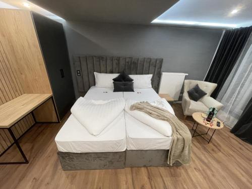 a bedroom with a large bed and a chair at Apartmenthaus Zeuthen 3 in Zeuthen