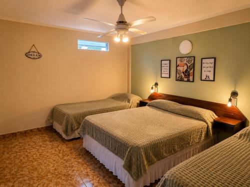 a bedroom with two beds and a ceiling fan at Hostel & Posada Noelia in Puerto Iguazú