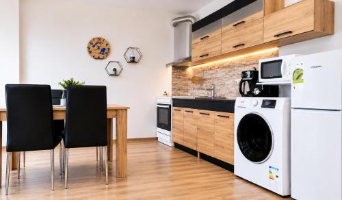 a kitchen with a table and a washer and dryer at T&M Stay Pamporovo in Pamporovo