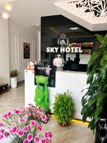 a shop with a green stool in a room with flowers at Sky Hotel Bắc Giang in Bắc Giang