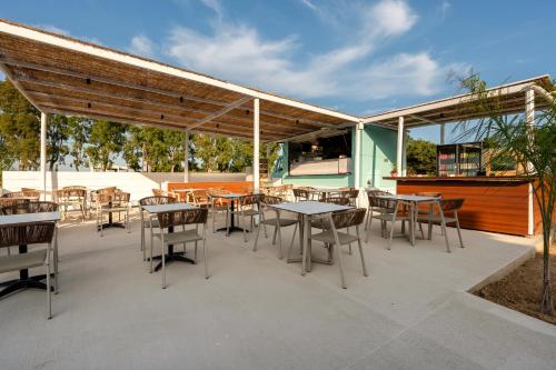 a patio with tables and chairs and a building at SolMare Premium Suites in Mastihari