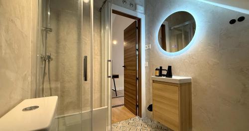 a bathroom with a shower and a sink and a mirror at La Posada de las Flores in Astorga