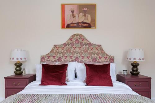 a bedroom with a bed with red pillows at The Greenhouse Ayr in Ayr