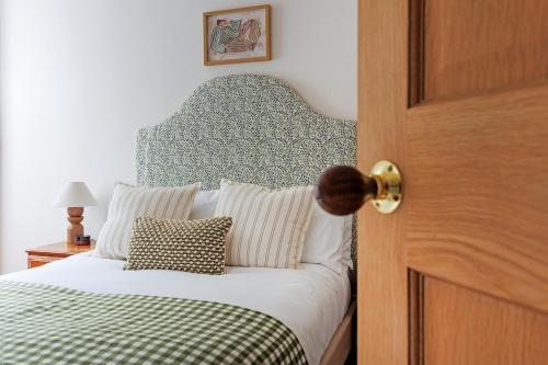 a bedroom door with a bed with a green and white blanket at The Greenhouse Ayr in Ayr