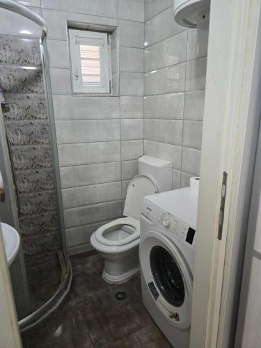 a bathroom with a toilet and a washing machine at Papillon in Visoko