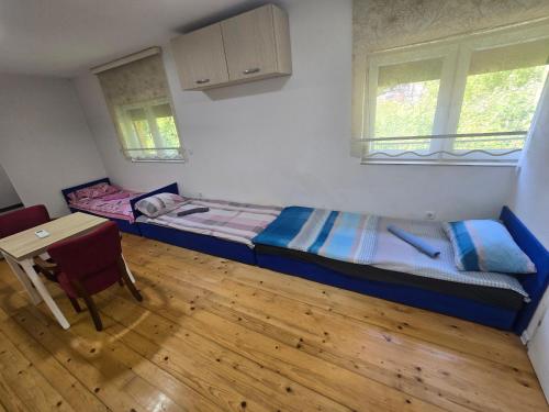 a small room with a bed and a table at Papillon in Visoko
