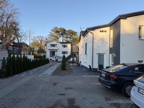 a street with two white buildings and a black car at Apartmenthaus Zeuthen 2 in Zeuthen