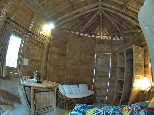 a room with a wooden cabin with a bed and a table at Pondok Salacca#bamboohouse# in Candidasa