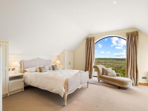 a bedroom with a bed and a window and a chair at Calla Lookout in Roundstone