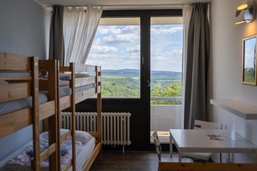a room with bunk beds and a table and a window at Shree Peetha Nilaya - Hindu Ashram in Springen