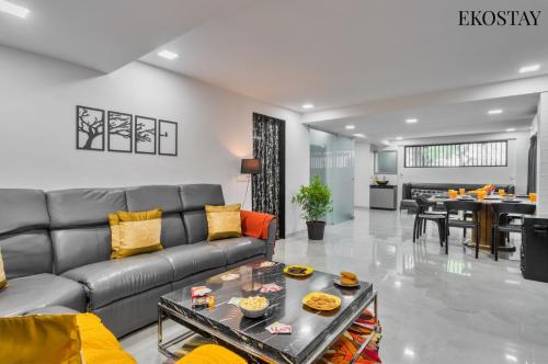 a living room with a couch and a table at EKOSTAY - ONYX Villa in Mumbai