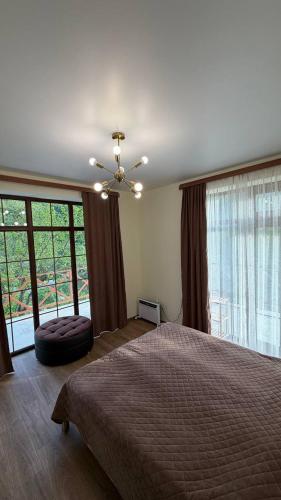 a bedroom with a bed and a large window at Relocation Dili House in Dilijan