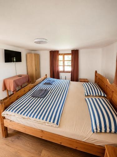 a bedroom with a large bed with blue and white stripes at PENSIUNEA BOCA VORONET in Voronet