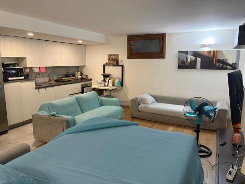 a living room with a couch and a kitchen at Monolocale Zefiro in Elmas