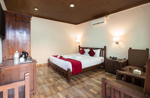 a bedroom with a bed and a chair in a room at The Culture Resort in Pokhara