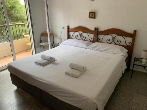a bedroom with a white bed with towels on it at Apartment Sunset Moraira City in Moraira