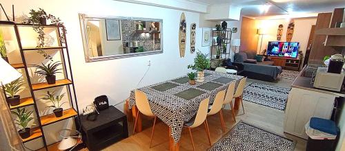 a living room with a dining table and a kitchen at Sesimbra Sea Apartment with Pool & Gym near Lisbon in Sesimbra