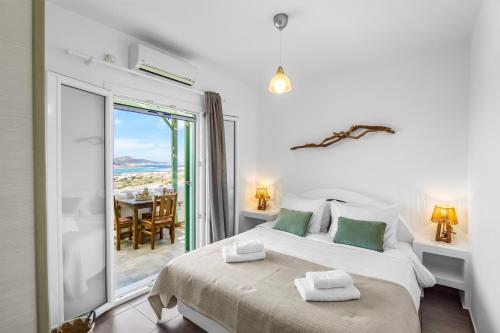 a bedroom with a bed with a view of the ocean at Salty Wind Antiparos Apartments and Studios in Agios Georgios